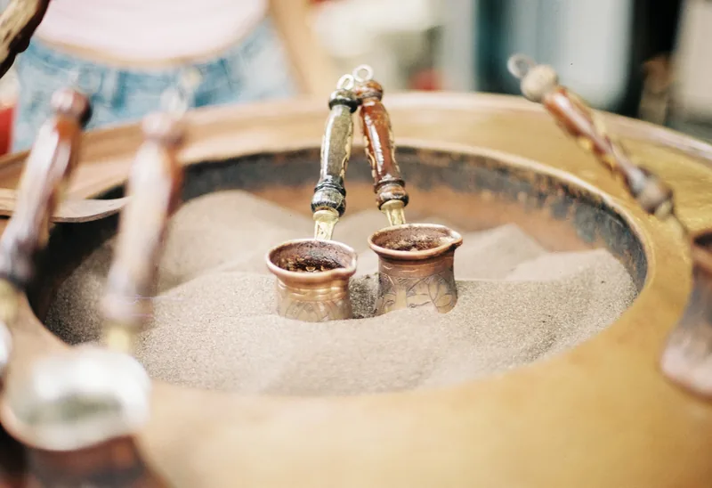 A small figurine and metal bowls on a tabletop.