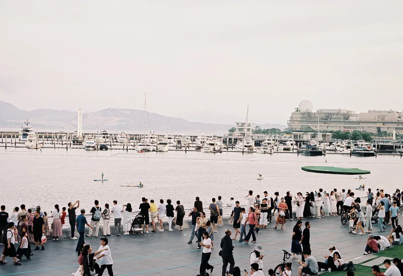 People gathered along a waterfront promenade.