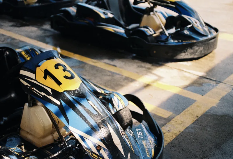A blue go-kart bearing the number thirteen.