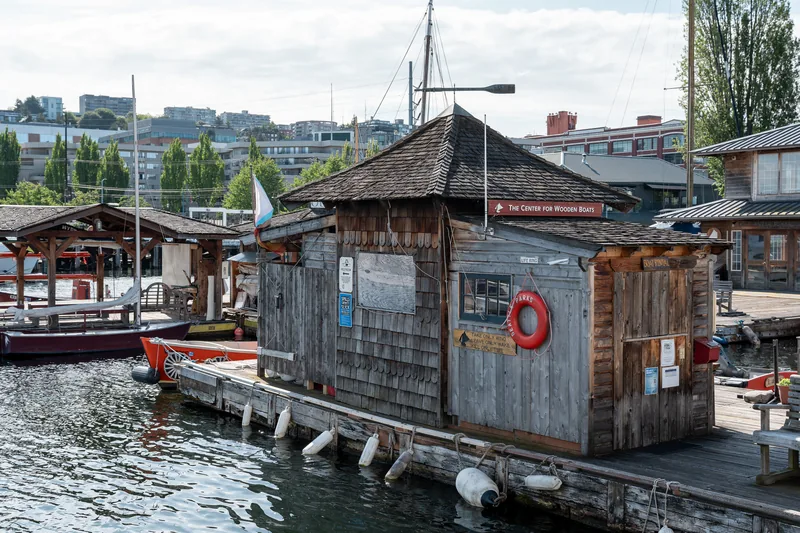 A wooden waterside shed beside a marina.
