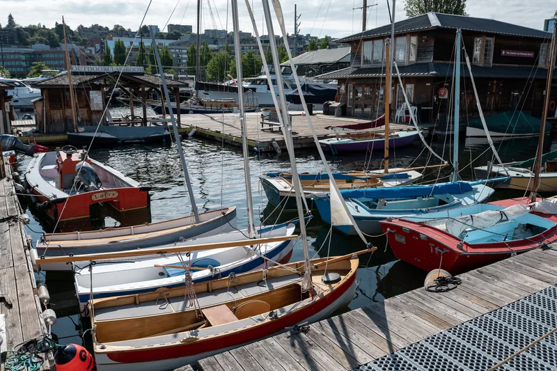 Wooden sailing boats lined up at a dock.