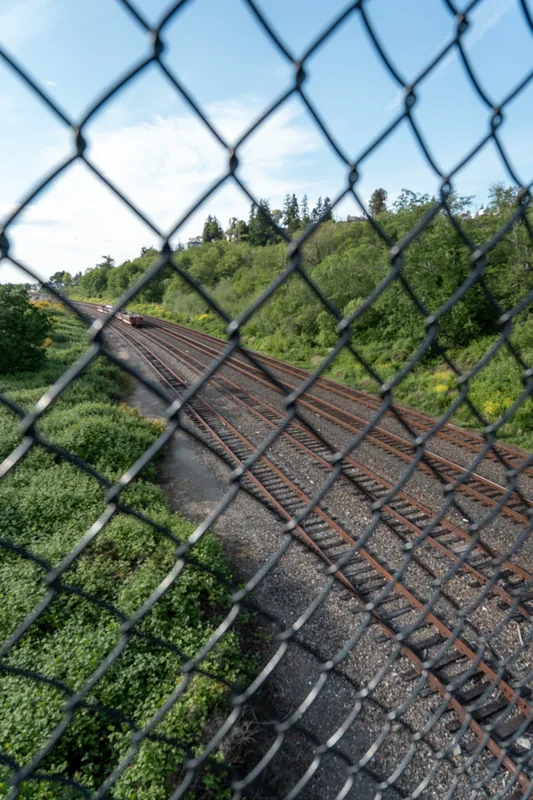 A sloping structure seen through a chain-link fence.