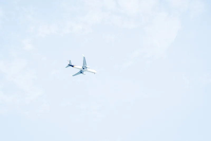 A small aircraft crossing a pale sky.