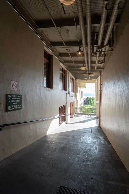 A shaded passageway with exposed ceiling beams.
