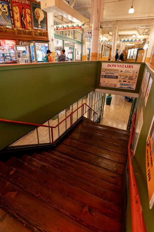 A stairway beside a brightly lit market entrance.
