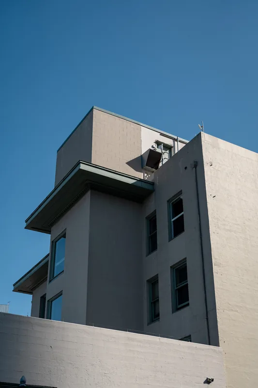 A concrete building against a clear blue sky.