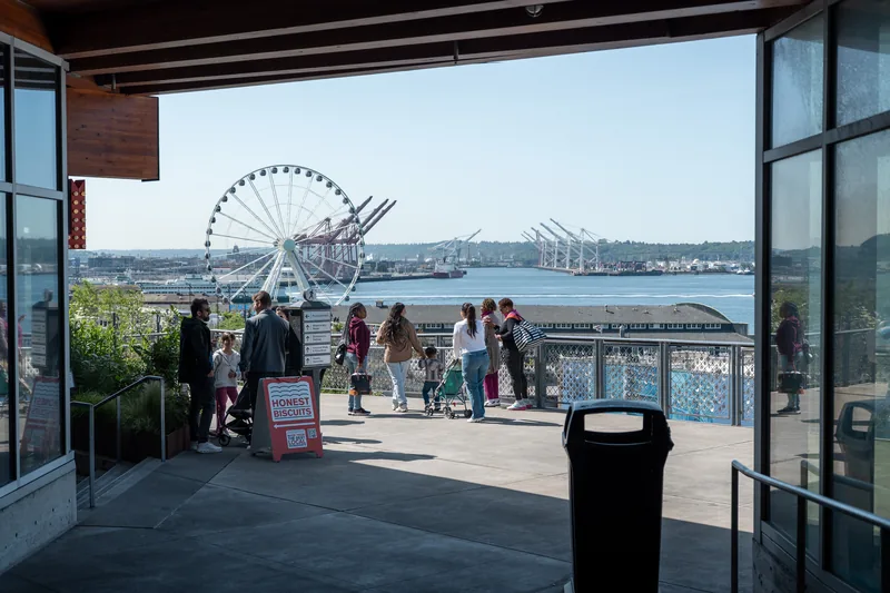 A waterfront Ferris wheel seen through an open doorway.