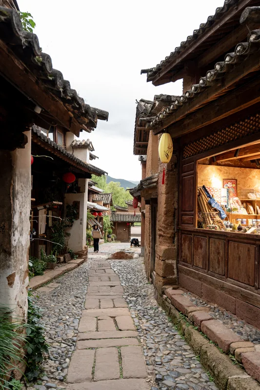 A stone lane between traditional wooden buildings.