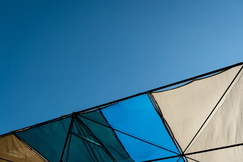A geometric sunshade against a deep blue sky.